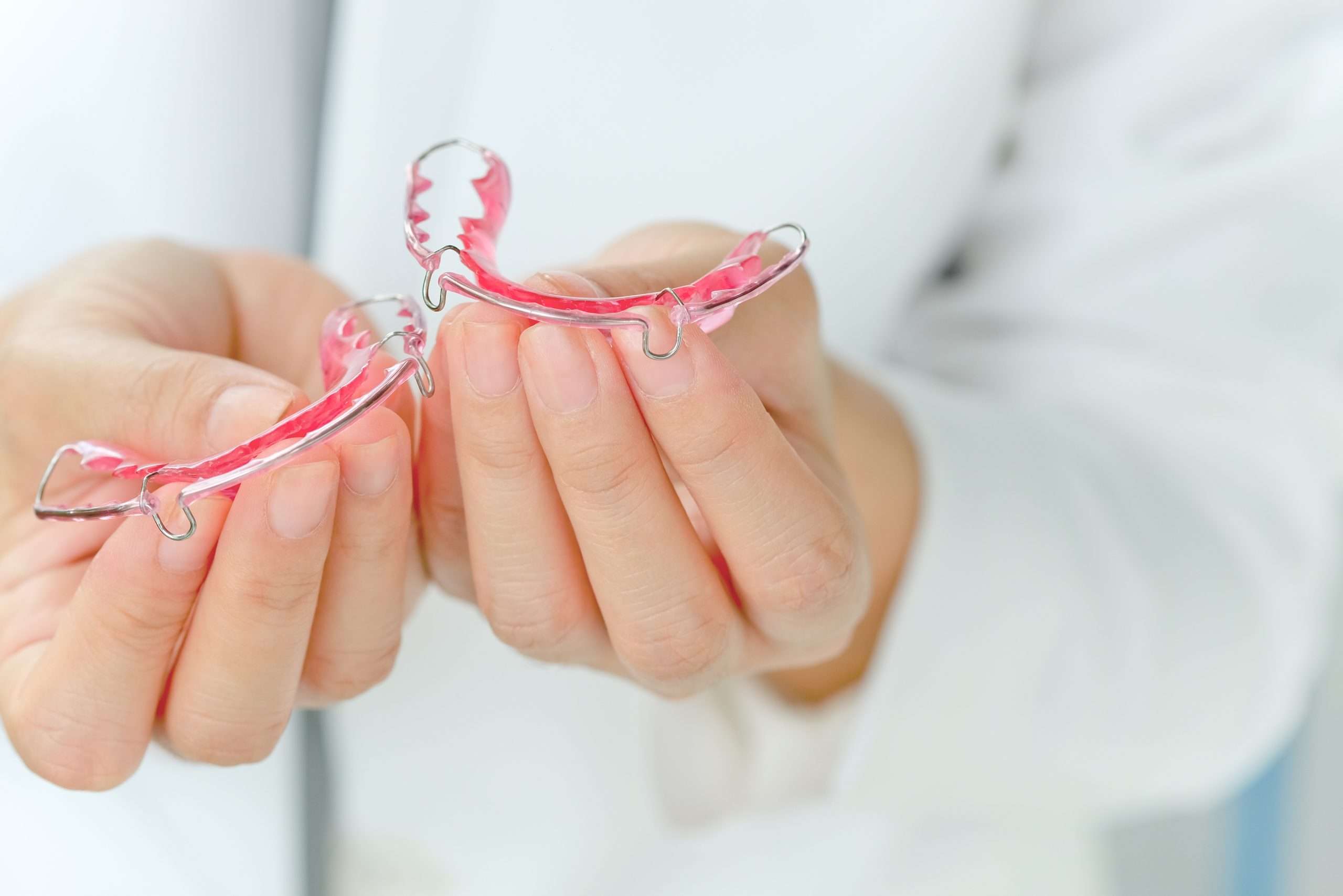 dentist holding retainers